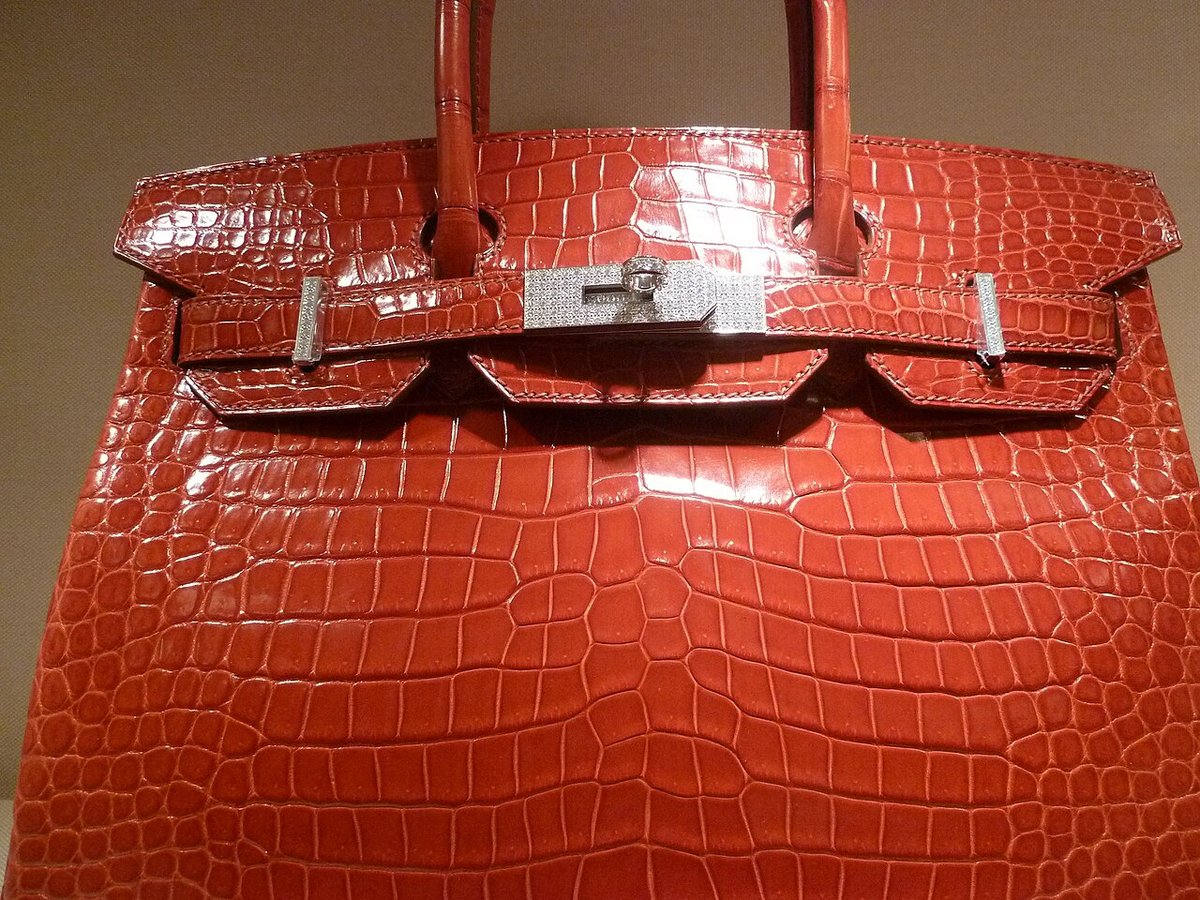 Close-up of a Hermès Birkin bag in glazed crocodile leather, showing symmetrical scale placement and diamond-set hardware